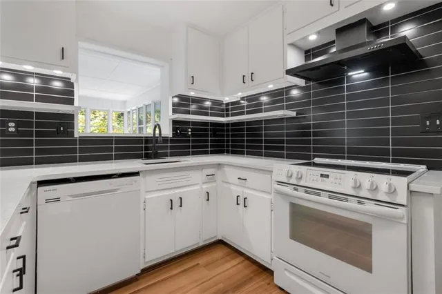 a kitchen with appliances cabinets and a stove top oven
