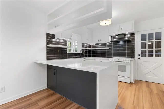 a kitchen with stainless steel appliances a stove a sink and a microwave