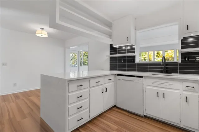 a kitchen with white cabinets and chandelier