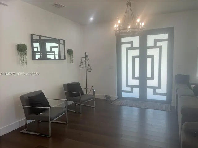 a view of a workspace with furniture and a window