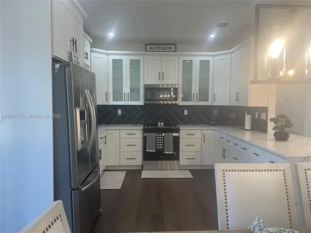 a kitchen with stainless steel appliances granite countertop a refrigerator and a stove