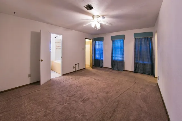a view of an empty room with a ceiling fan