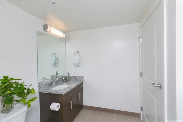a bathroom with a granite countertop sink and a mirror
