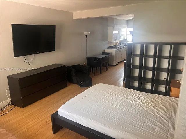 a bedroom with a bed tv and a window