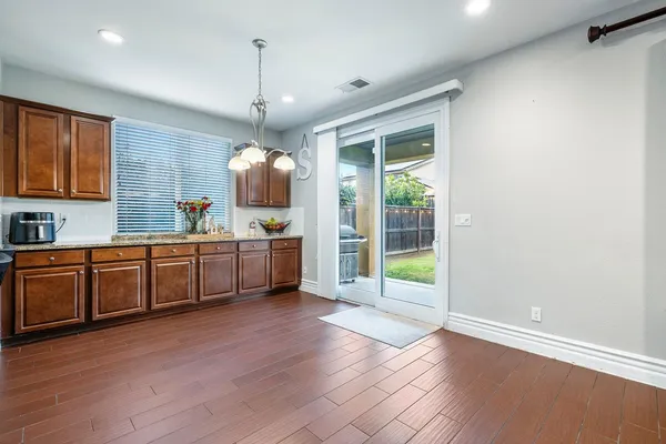 a kitchen with stainless steel appliances granite countertop a sink window and wooden floor