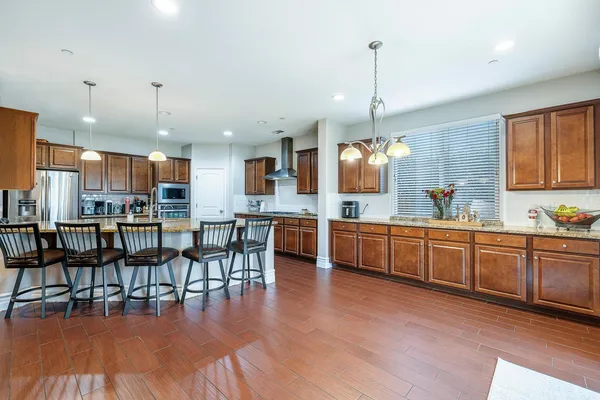 a kitchen with stainless steel appliances granite countertop wooden floor cabinets and a center island