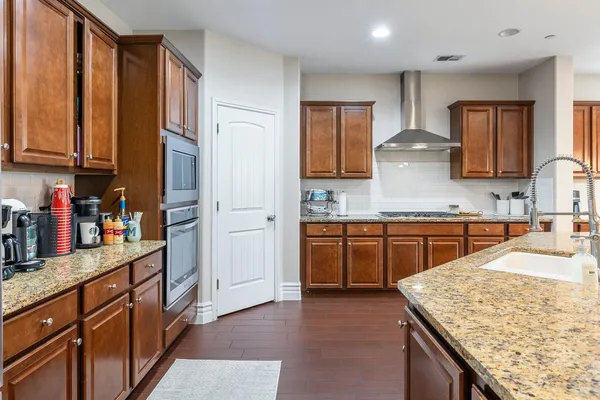 a kitchen with stainless steel appliances granite countertop wooden cabinets a sink and dishwasher