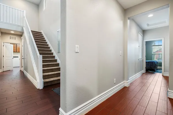 a view of a hallway with wooden floor and stairs
