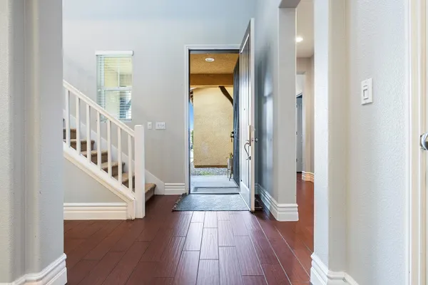 a view of a hallway with wooden floor and staircase