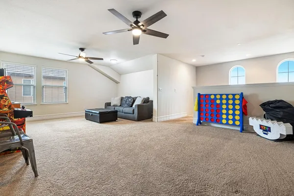a living room with furniture a ceiling fan and a window