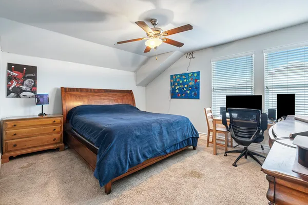 a bedroom with a bed and a chair with the potted plant