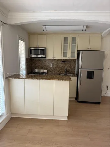 a kitchen with stainless steel appliances a refrigerator sink and microwave