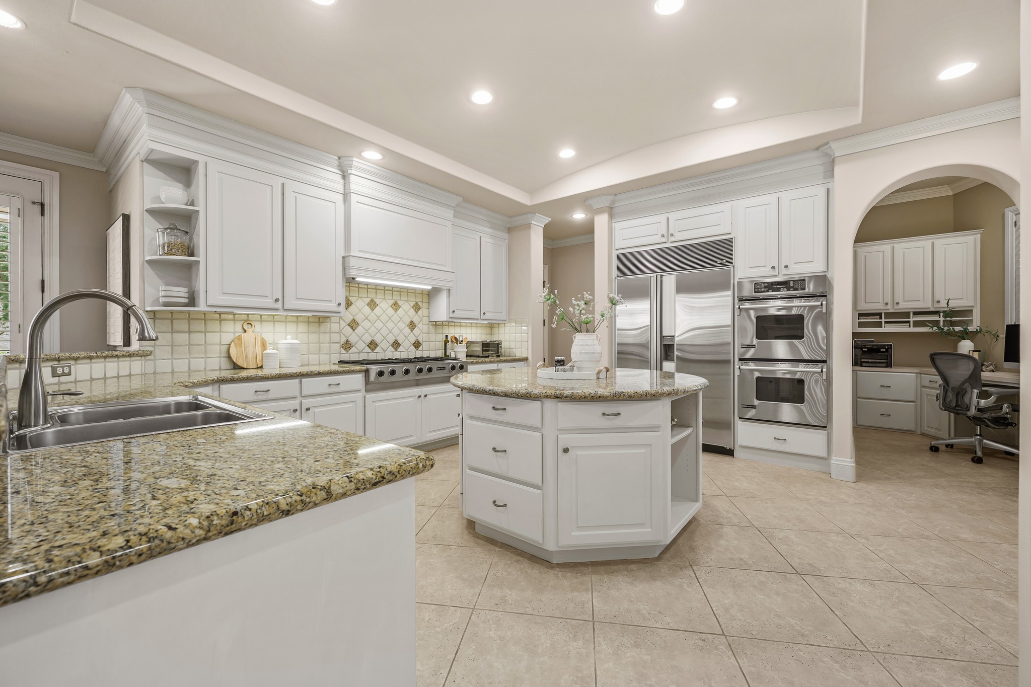 5200 Rico Cove Austin, TX 78731 - Photo 14 of 40 Polished stone countertops pair with white cabinetry and tiled flooring in this modern kitchen.