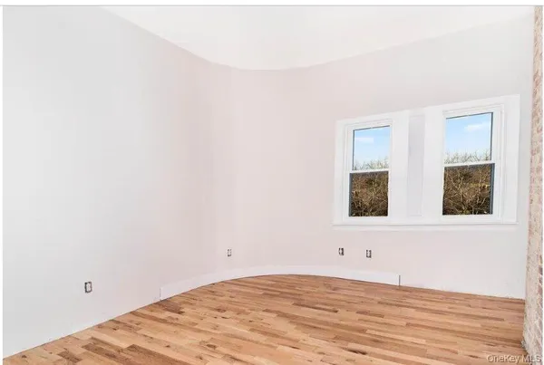 a view of a room with wooden floor and windows