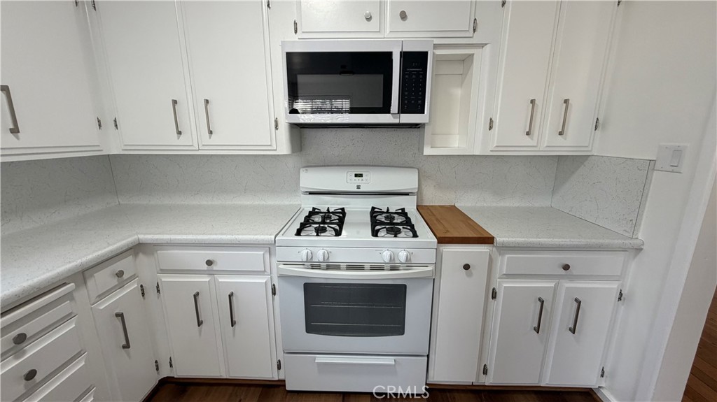 3590 Buchanan Street Riverside, CA 92503 - Photo 20 of 73 a kitchen with white cabinets and white stove