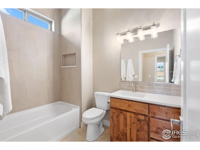 a view of an empty room and a chandelier fan