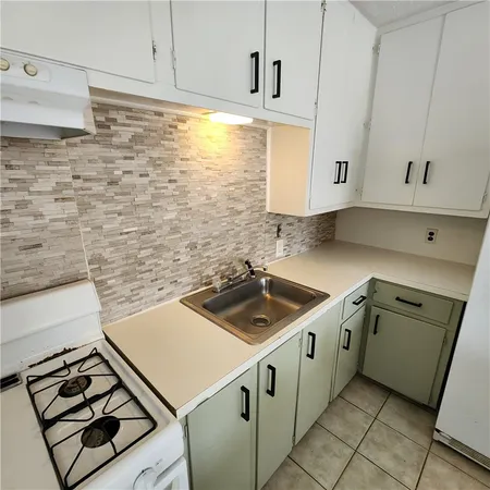a kitchen with sink stove and cabinets