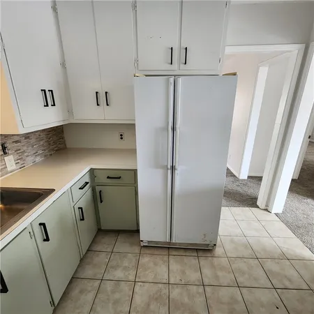 a kitchen with a refrigerator sink and cabinets