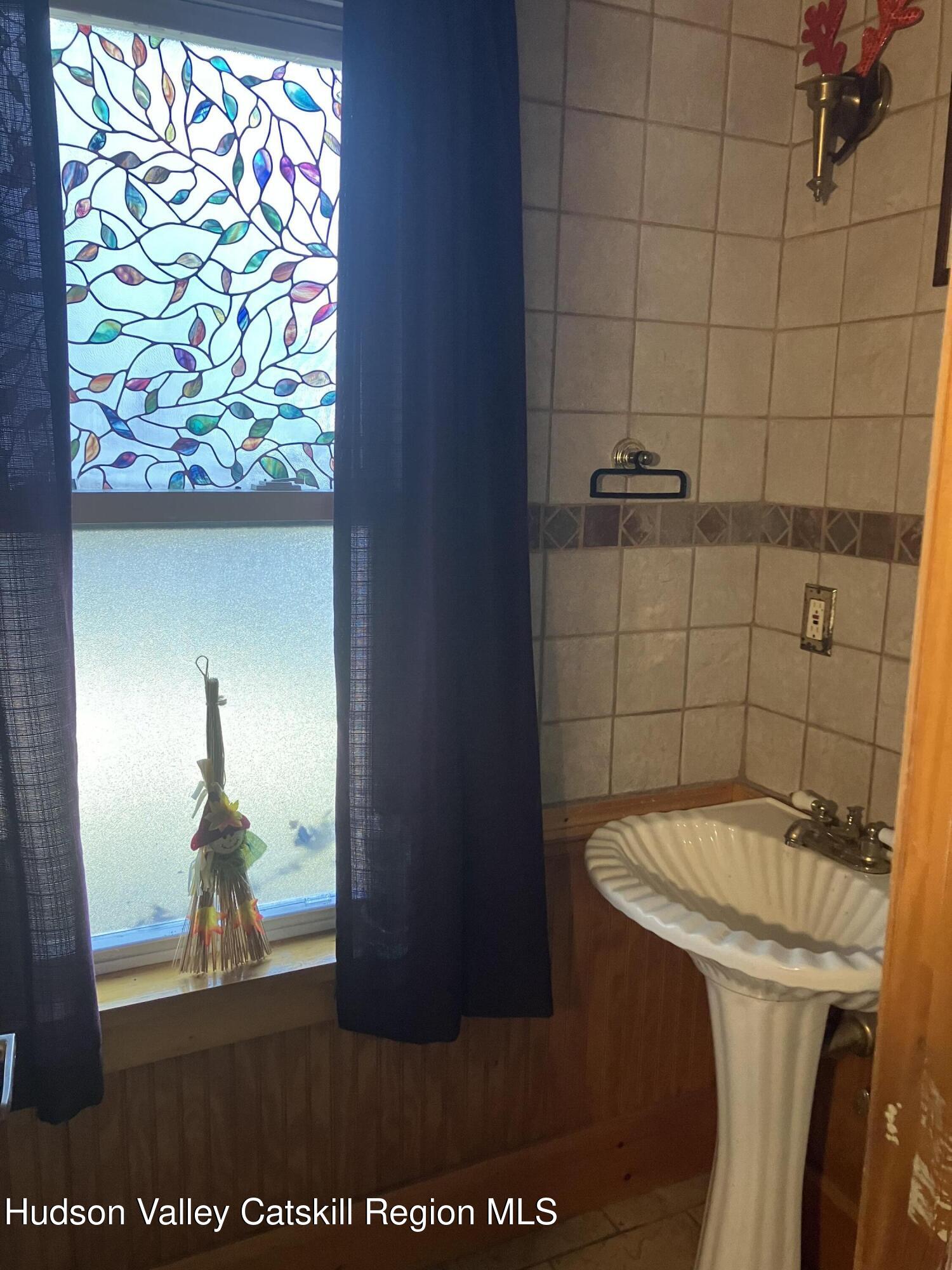 147 North Street Catskill, NY 12414 - Photo 13 of 23 a bathroom with a sink and a mirror