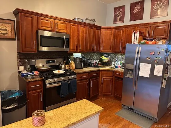 a kitchen with stainless steel appliances granite countertop a stove a sink and a microwave