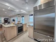 a kitchen with kitchen island granite countertop a sink stove and cabinets