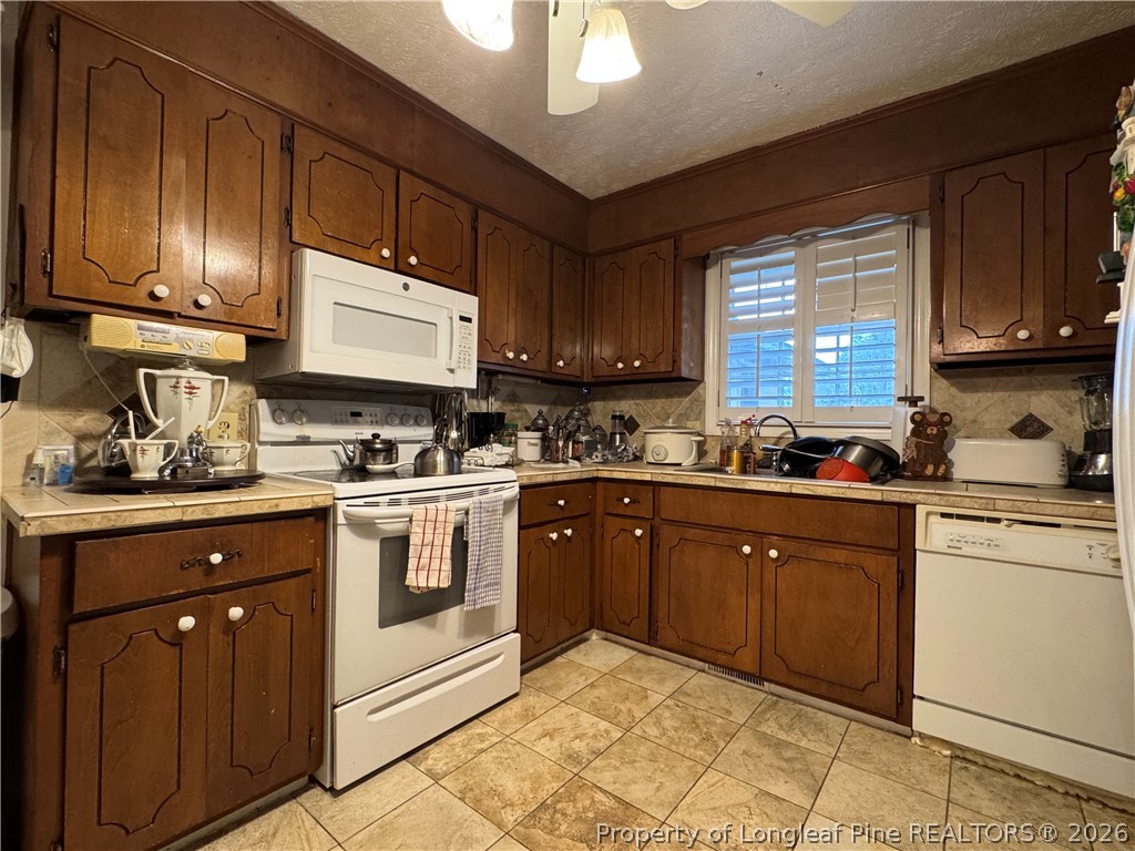 408 Old Farm Road Raeford, NC 28376 - Photo 13 of 27 a kitchen with cabinets a sink and white appliances