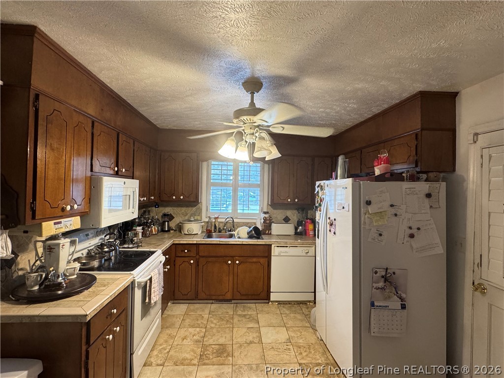 408 Old Farm Road Raeford, NC 28376 - Photo 15 of 27 a kitchen with refrigerator a sink and cabinets