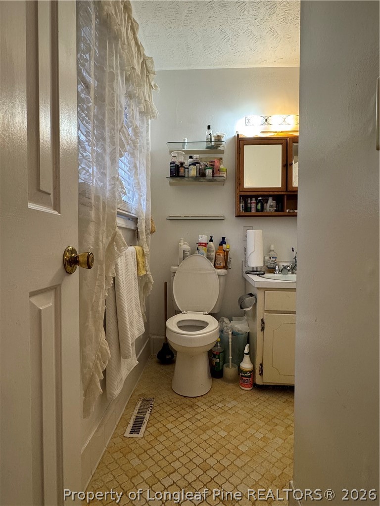408 Old Farm Road Raeford, NC 28376 - Photo 26 of 27 a bathroom with a toilet a sink and mirror