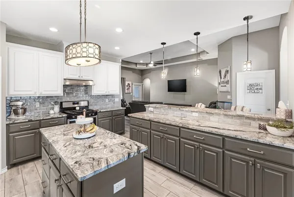a kitchen with a sink a stove and chairs