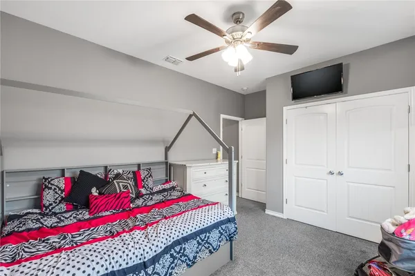 a bedroom with a large bed and a chandelier