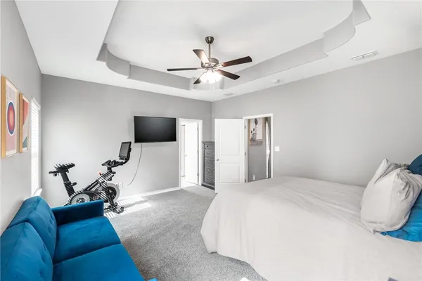 a spacious bedroom with a bed and a flat screen tv