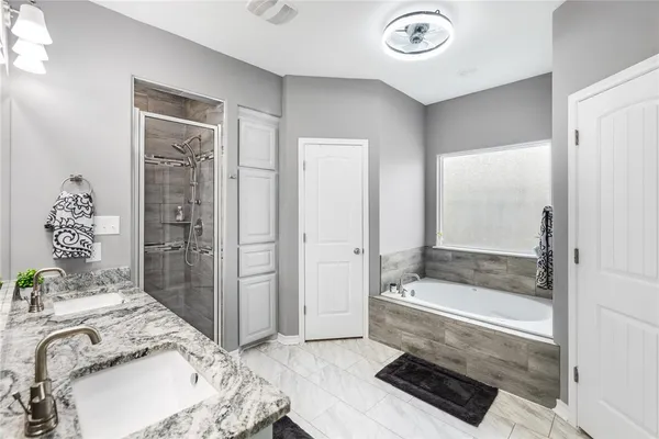 a bathroom with a tub sink and shower