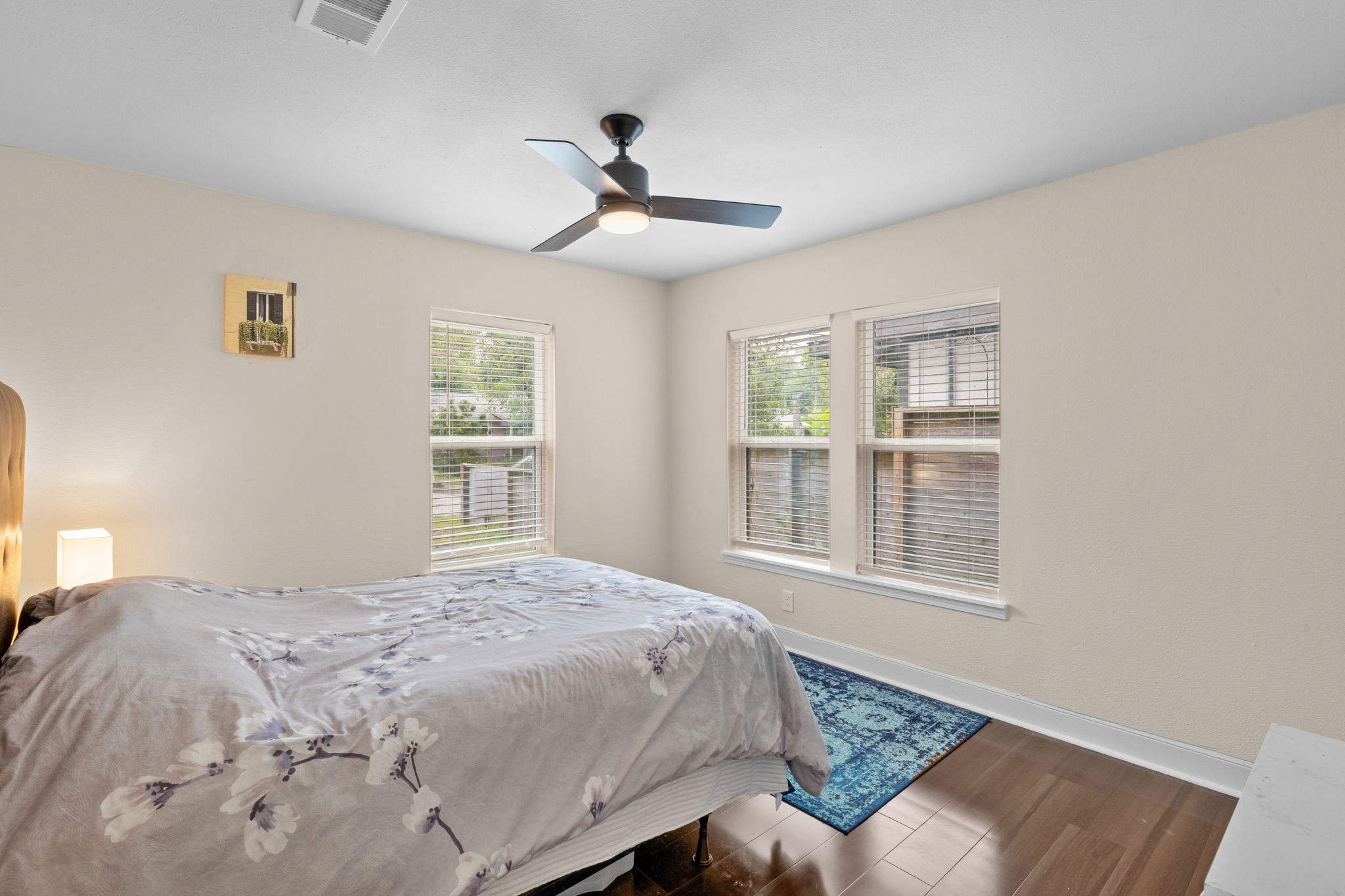 907 East 53rd Street Austin, TX 78751 - Photo 13 of 36 Hardwood floors and multiple windows create a peaceful and naturally illuminated bedroom retreat.