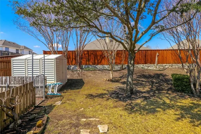 a view of a yard with wooden fence