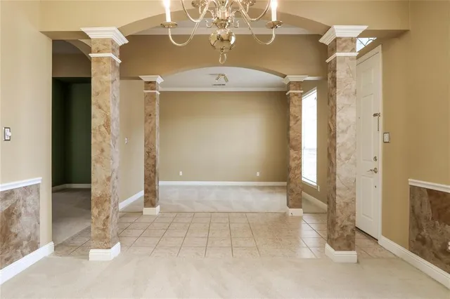 a view of a hallway with a chandelier fan and living room view
