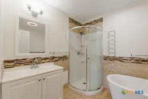 a bathroom with a granite countertop sink a toilet a mirror and shower