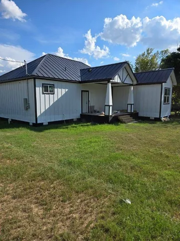 a backyard of a house with table and chairs