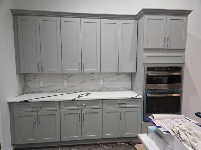 a kitchen with white cabinets and sink