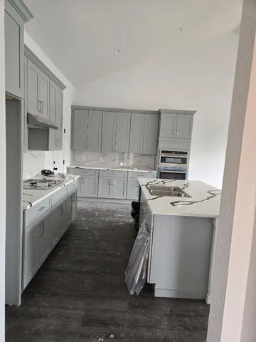 a kitchen with a sink a stove and cabinets