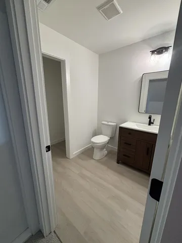 a bathroom with a sink a toilet a mirror and vanity