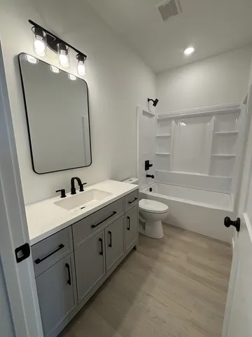 a bathroom with a double vanity sink mirror and toilet