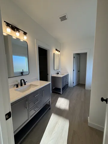 a bathroom with a double vanity sink and mirror