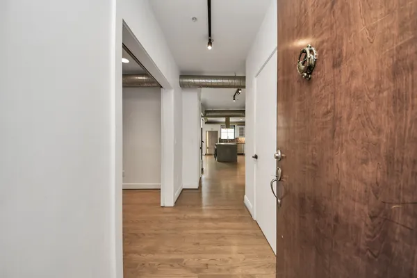 an empty room with wooden floor and a ceiling fan