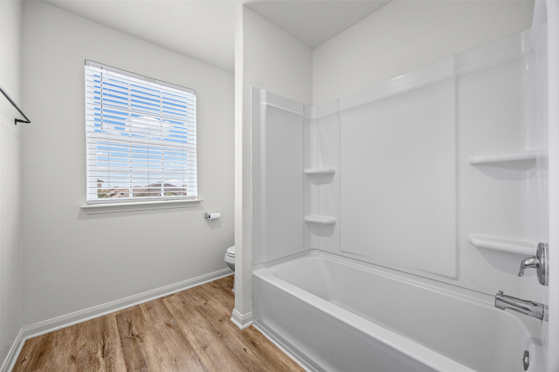 19812 Hubert R Humphrey Road Manor, TX 78653 - Photo 17 of 29 A well-appointed bathroom offers a clean tub and shower combination with a bright window providing natural light.