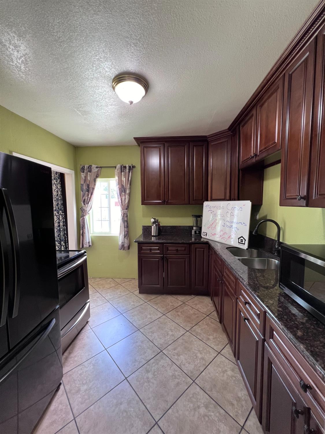 281 West Wilson Street Rialto, CA 92376 - Photo 6 of 15 a kitchen with granite countertop wooden cabinets stainless steel appliances and a sink