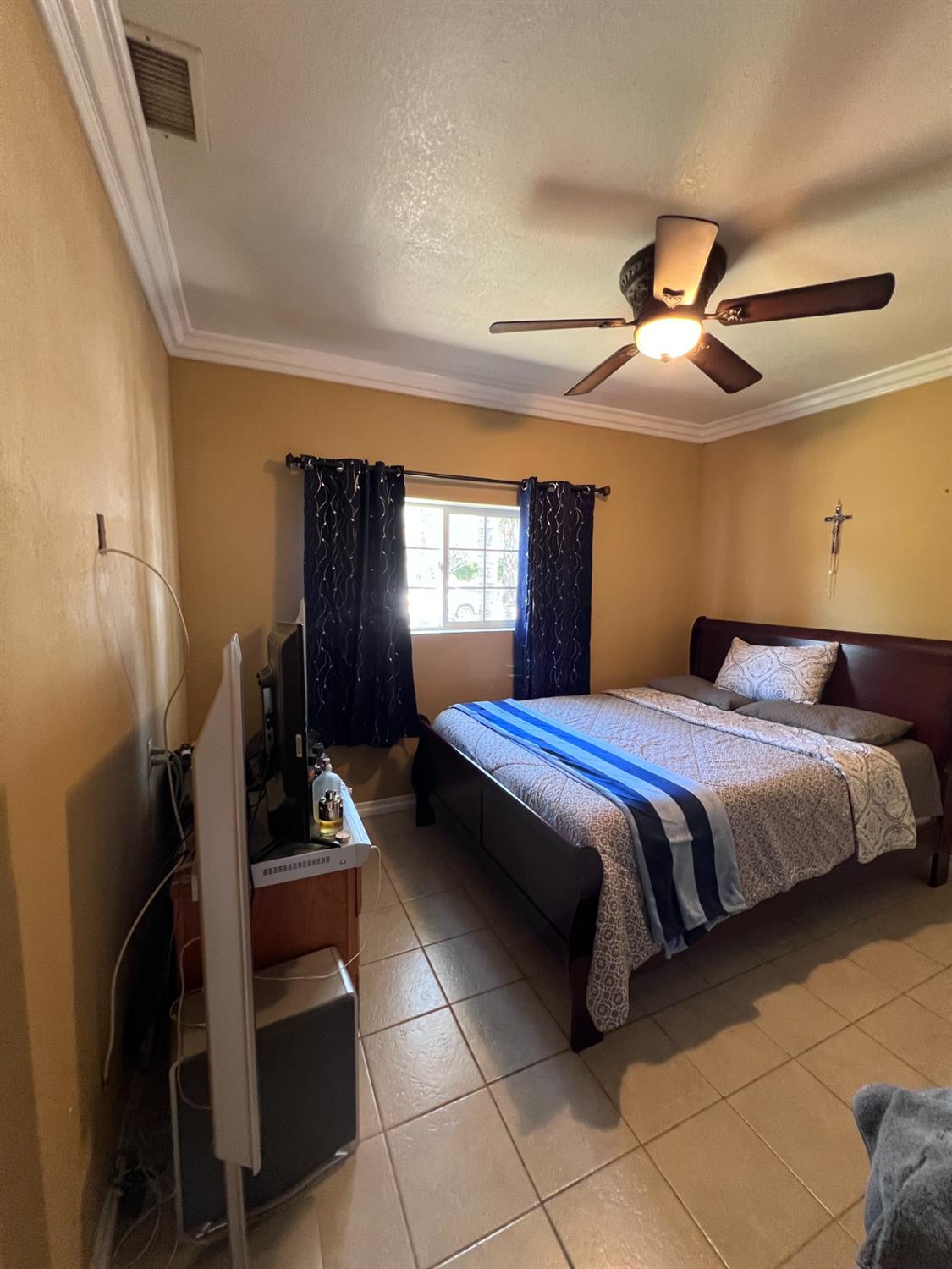 281 West Wilson Street Rialto, CA 92376 - Photo 9 of 15 a bedroom with a bed and a chandelier