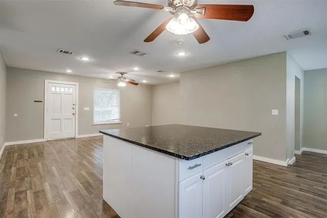 a kitchen with stainless steel appliances kitchen island granite countertop a stove a sink and a refrigerator