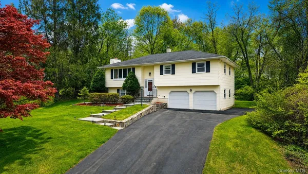 a front view of a house with a yard and trees