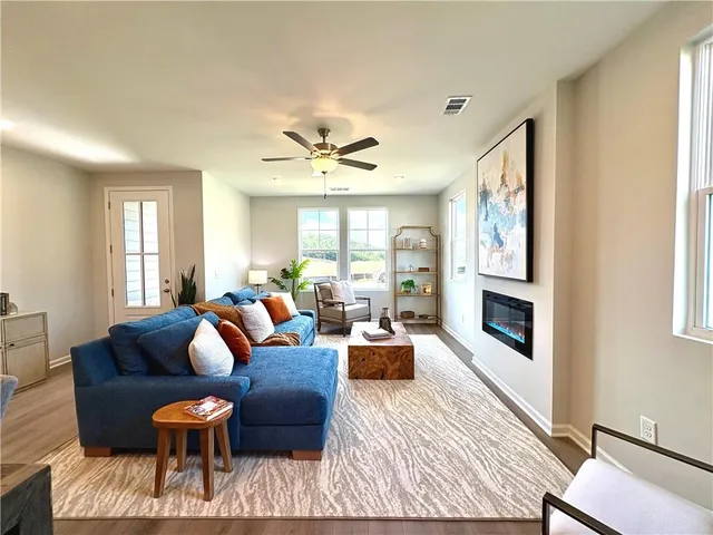 a living room with furniture a wooden floor and a chandelier