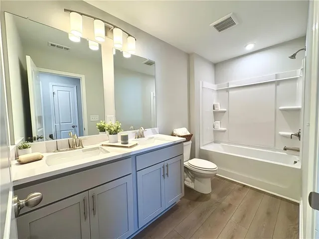 a bathroom with a sink and mirror with toilet